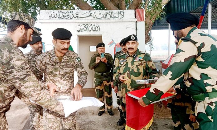 Indian and Pakistani soldiers greet each other at international border