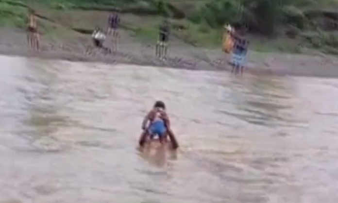 Man carries 8-month-old girl across swollen stream