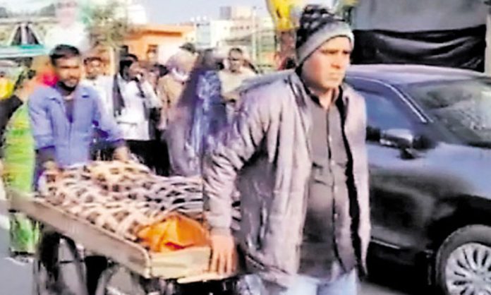 A husband carrying his wife's dead body on a cart